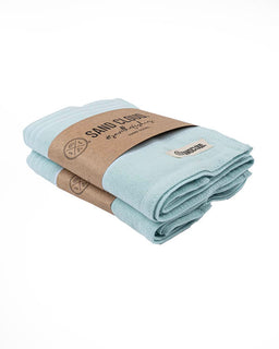 Folded light blue towel with brown paper wrap and 'Sand Cloud' branding on a white background
