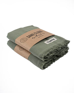 Folded green towels with brown paper wrap and visible branding on a white background