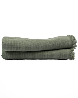 Folded green towel on a white background