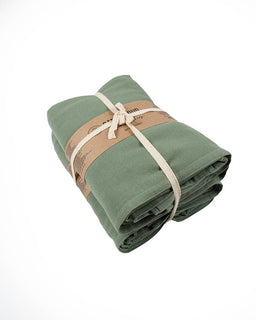 Folded green towel tied with a beige ribbon on a white background