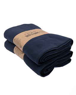 Two folded navy blue towels with a brown paper towel on a white background