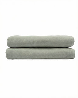 Two folded light green towels on a white background