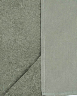 Close-up of a textured green fabric with a diagonal seam.