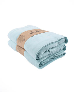 Folded light blue towel with a brown label on a white background