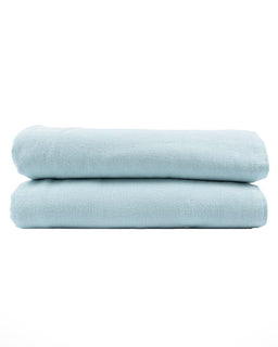 Two light blue folded towels on a white background