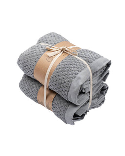 Stack of gray towels tied with a beige ribbon on a white background