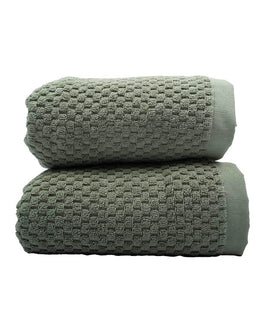 Two green textured towels stacked on a white background