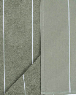 Close-up of green fabric with white stripes and a diagonal fold.