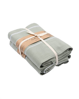 Folded light green towel with a brown paper wrap on a white background
