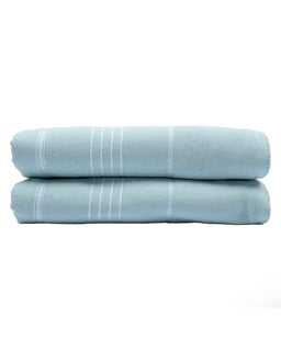 Two light blue towels stacked on a white background