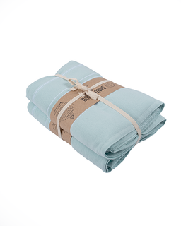 Folded light blue towel with a brown paper wrap on a white background