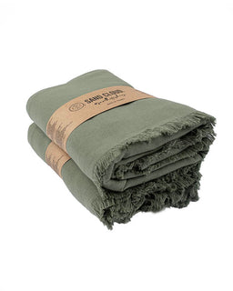 Green towel with a brown label on a white background