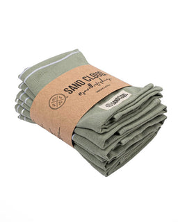 Folded green towels with a brown paper wrap displaying 'SAND CLOUD' brand on a white background.