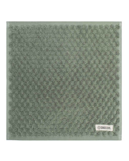 Green textured towel with a brand label on a white background