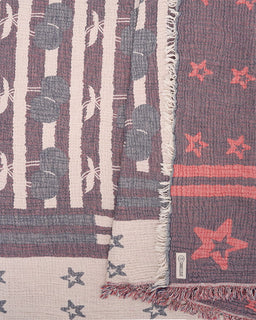 beach towel with star patterns in red, blue, and white on a woven background.