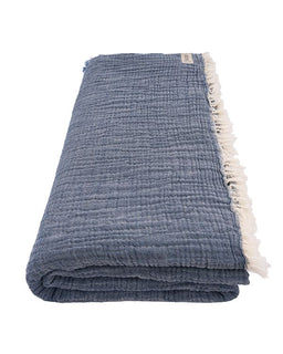 Folded blue textured blanket with white fringe on a white background