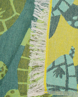 Close-up of a colorful towel with turtle patterns and frayed edge.
