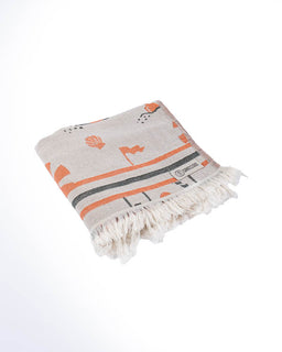Folded towel with orange and black patterns on a white background