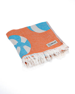 Orange and blue patterned towel with white fringe on a white background
