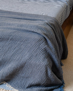 Blue textured blanket draped over a wooden surface