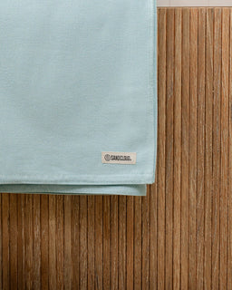 Light blue fabric with a brand label on a wooden surface