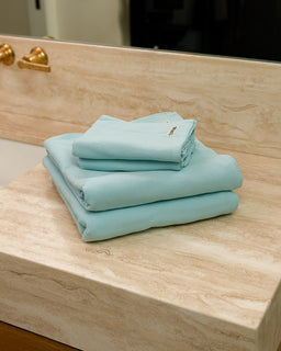Stack of light blue towels on a wooden surface