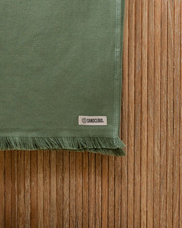 Green fabric with a brand label on a wooden surface