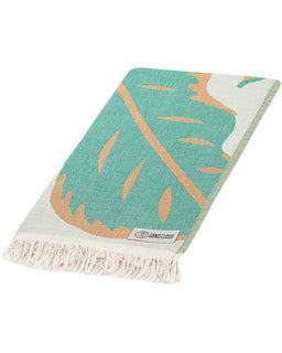 Folded view of beach towel with tropical leaves design on a white background