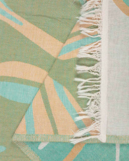 close up shot of beach towel with tropical leaves design 