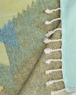 Close-up of a textured fabric with tassels on a multicolored background