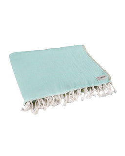 Light blue towel with white tassels on a white background