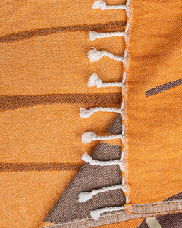 Close-up of a textured fabric with orange, brown, and white colors.