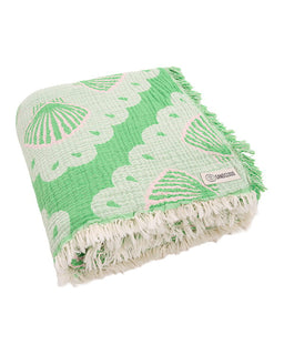 Green and white patterned blanket with fringes on a white background