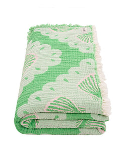 Green textured blanket with leaf pattern on a white background