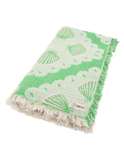 Green and white patterned towel with shell design on a white background