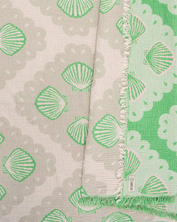 Textile with green shell pattern on a beige background