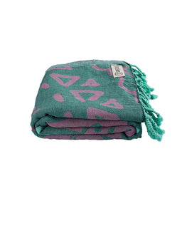 Folded teal and pink patterned towel with tassels on a white background