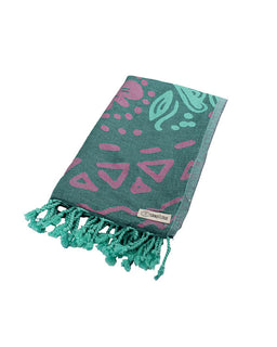 Teal and pink patterned towel with tassels on a white background