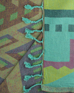 Close-up of patterned towel with tassels and geometric designs.