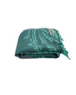 Green patterned towel with tassels on a white background