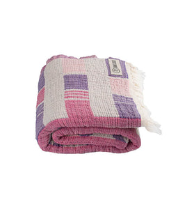 Folded pink and purple checkered towel with tassels on a white background