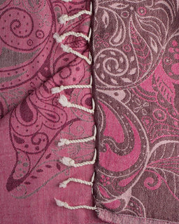 Close-up of a pink and gray paisley fabric with white lace trim.