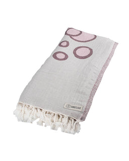 Gray towel with pink circular patterns and tassels on a white background