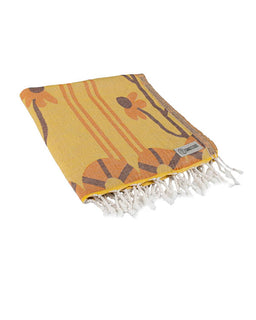 Yellow towel with floral patterns and white fringes on a white background