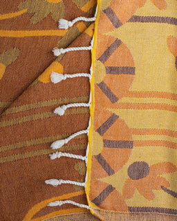 Close-up of a fabric with autumn-themed design featuring pumpkins and leaves.