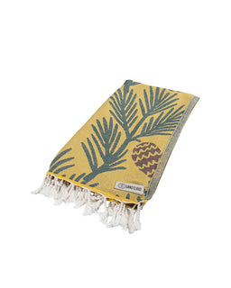 Yellow towel with green leaf pattern and white tassels on a white background