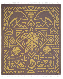 Patterned towel with dolphins, turtle, and shells on a brown background