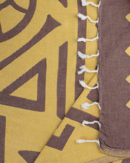 Close-up of a fabric with brown geometric patterns on a yellow background