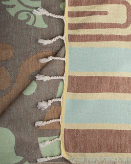 Close-up of a textured fabric with colorful stripes and tassels.