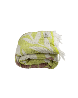 Folded green and white patterned towel with fringes on a white background